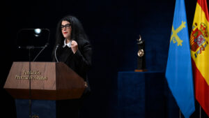 Marjane Satrapi hablando en un evento con banderas de Espa&ntilde;a y Asturias