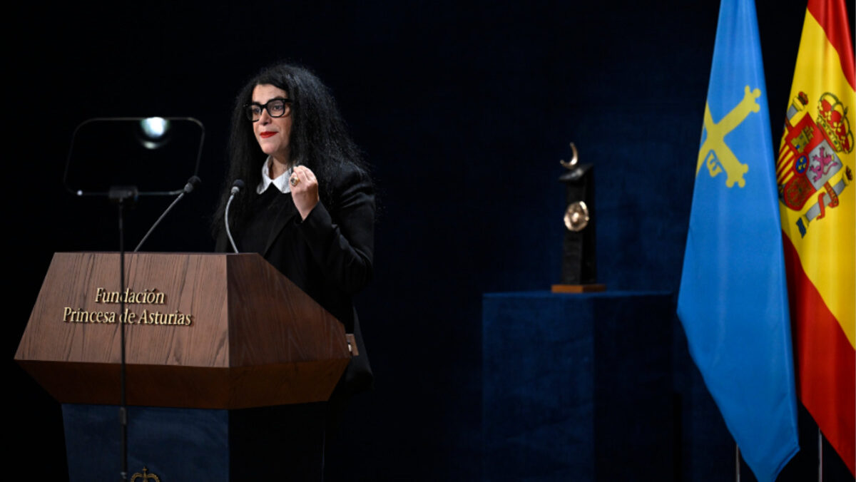 Marjane Satrapi hablando en un evento con banderas de Espa&ntilde;a y Asturias