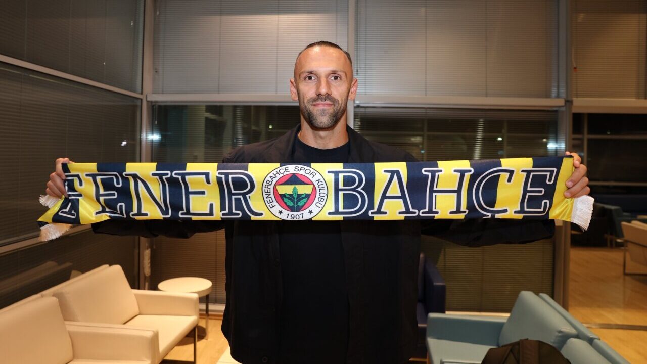 Vedat Muriqi sosteniendo una bufanda del Fenerbah&ccedil;e en una sala