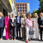 Grupo de personas posando frente a un edificio en un evento político