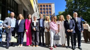 Grupo de personas posando frente a un edificio en un evento pol&iacute;tico