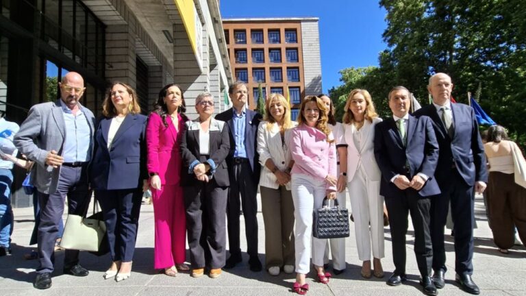 Grupo de personas posando frente a un edificio en un evento pol&iacute;tico