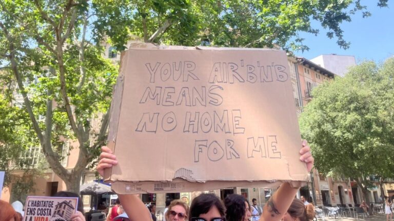 Persona sostiene un cartel en protesta por la vivienda en Palma.