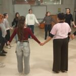 Grupo de personas en c&iacute;rculo participando en una actividad de danza inclusiva.