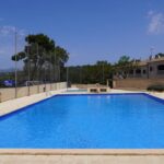 Piscina municipal renovada en Marratx&iacute; con cielo azul y &aacute;rboles