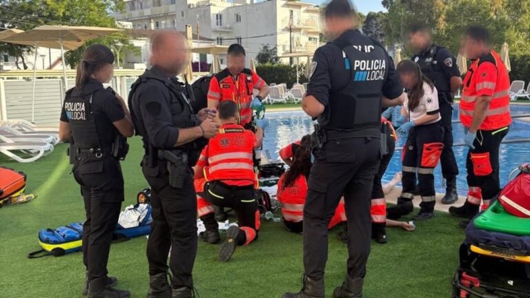 Agentes de la Policía Local y socorristas atendiendo a un joven en una piscina