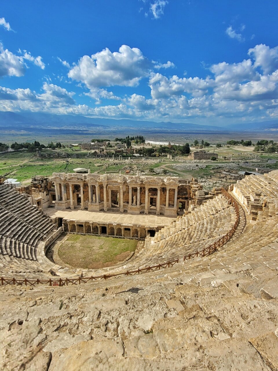 Vista panorámica de un antiguo teatro arqueológico con paisaje verde