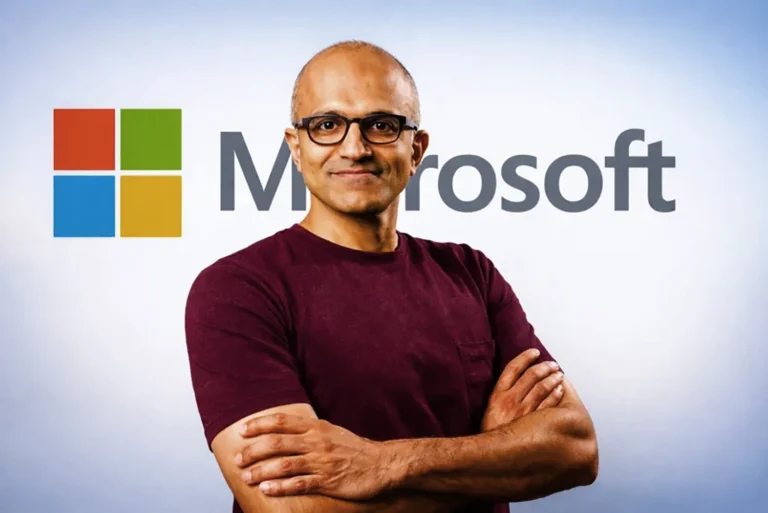 Satya Nadella, CEO de Microsoft, con el logo de la empresa detr&aacute;s.