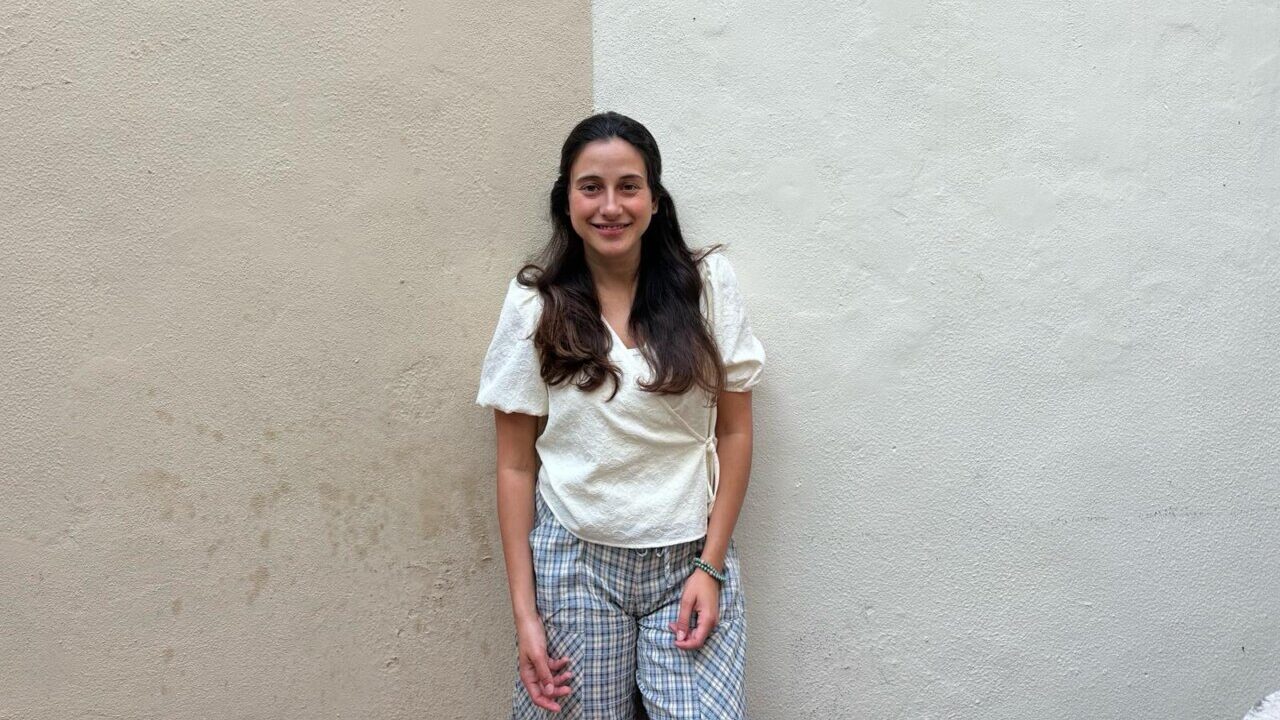 Joven sonriente en un fondo de pared clara