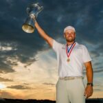 Wyndham Clark levantando el trofeo del U.S. Open 2026 al atardecer