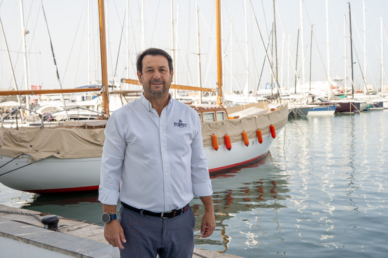 Hombre de pie junto a un barco en un puerto