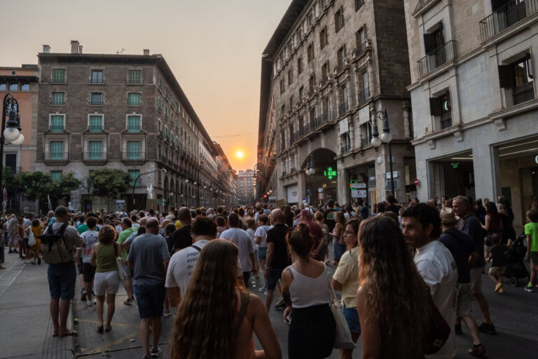 Multitud de personas en una manifestaci&oacute;n antiturismo en Mallorca al atardecer