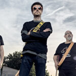 Miembros de la banda Monkey Jack Band posando con camisetas y gafas de sol