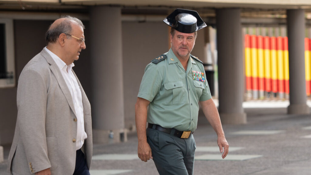 Dos hombres conversando, uno vestido de Guardia Civil