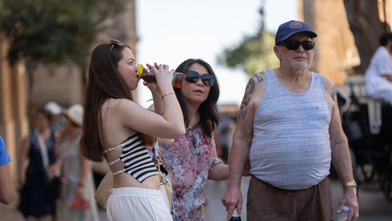 Grupo de turistas disfrutando de una bebida en un d&iacute;a caluroso