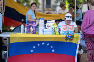 Mesa con productos de ayuda humanitaria y bandera de Venezuela en Palma.