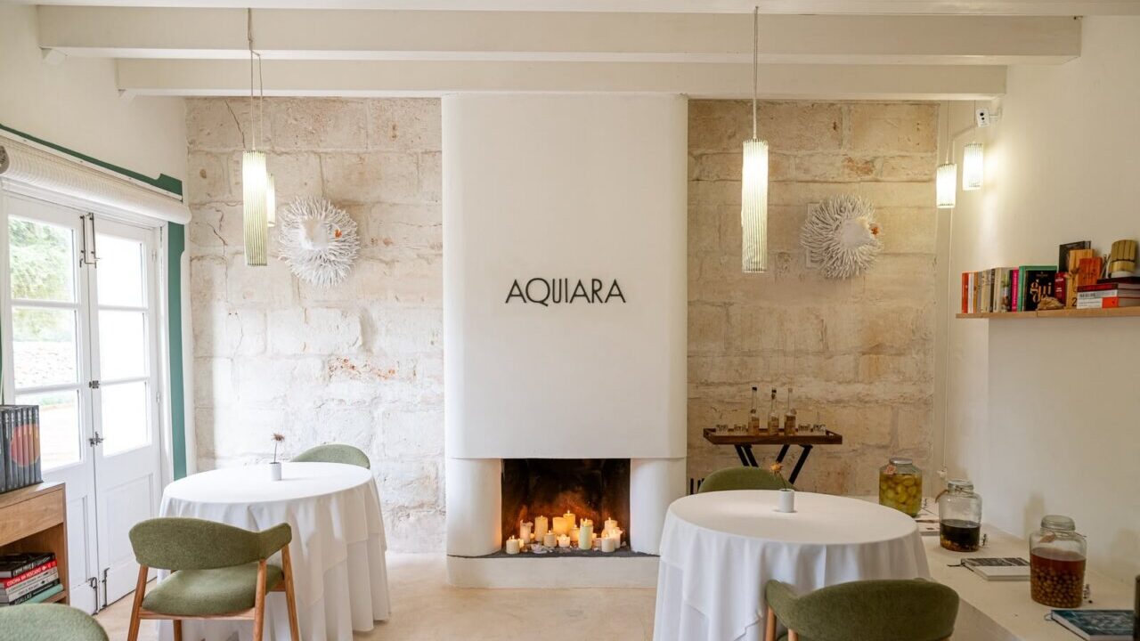Interior del restaurante Aquiara con mesas y decoraci&oacute;n elegante