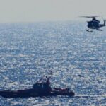Helic&oacute;ptero y barco de rescate en el mar durante una operaci&oacute;n de migrantes