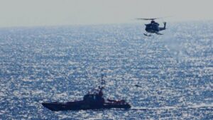 Helic&oacute;ptero y barco de rescate en el mar durante una operaci&oacute;n de migrantes