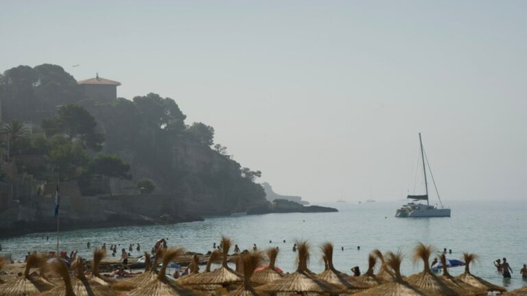 Bancos de niebla sobre la bahía de Palma con turistas en la playa