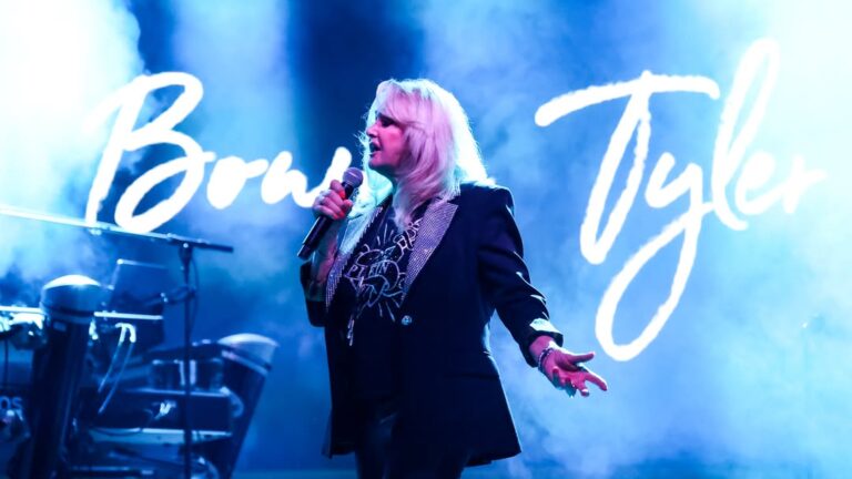 Bonnie Tyler actuando en un escenario con luces de fondo