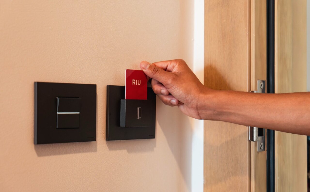 Persona insertando tarjeta RIU en un lector de puerta