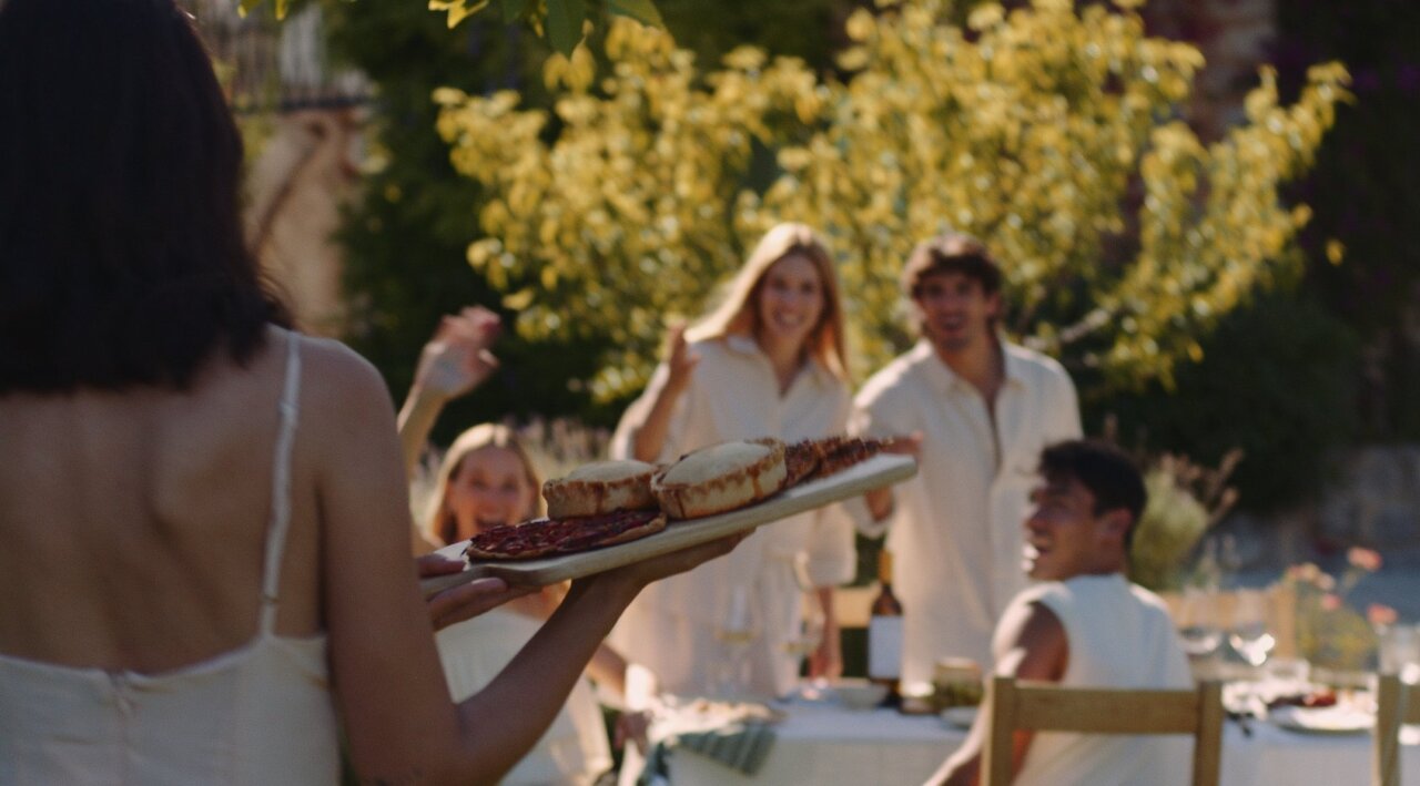 Grupo de amigos disfrutando de una comida al aire libre en un ambiente festivo