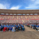 Ceremonia de graduación en un estadio con estudiantes sentados