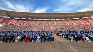 Ceremonia de graduaci&oacute;n en un estadio con estudiantes sentados
