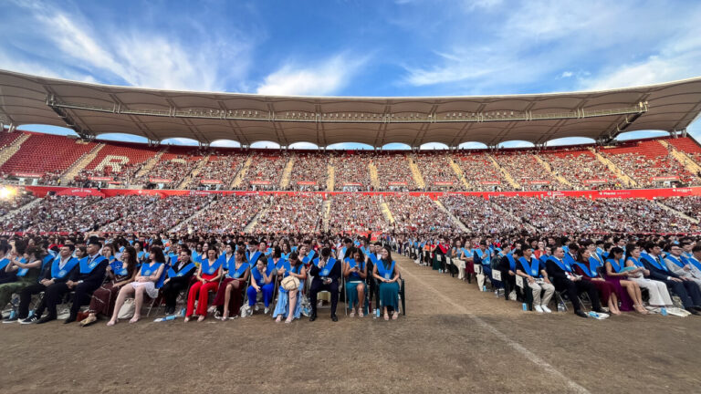 Ceremonia de graduaci&oacute;n en un estadio con estudiantes sentados