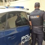Agente de polic&iacute;a nacional junto a un coche patrulla en Palma
