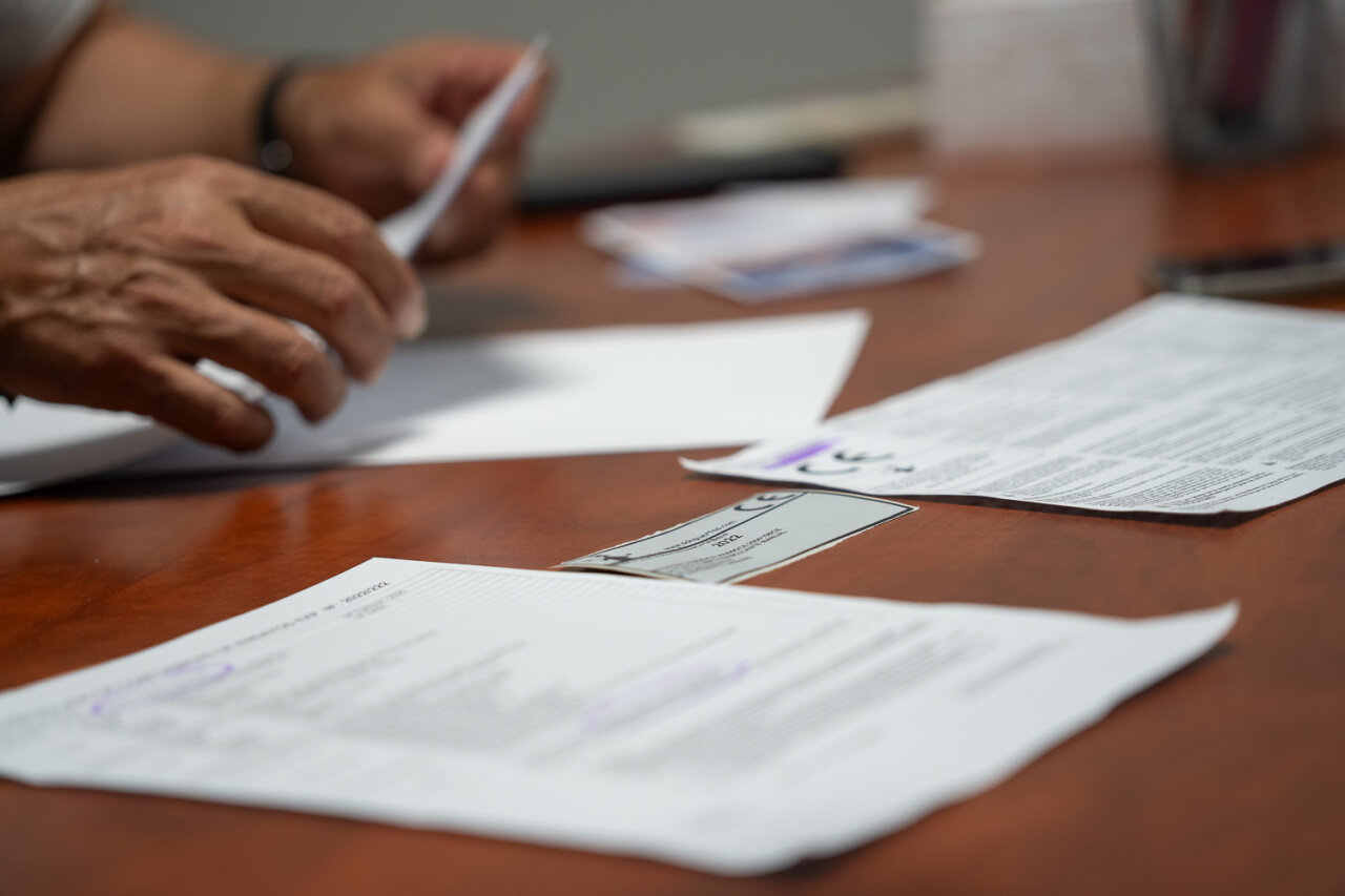 Manos revisando documentos sobre puertas automáticas en una mesa