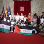 Grupo de ni&ntilde;os sosteniendo banderas en un evento