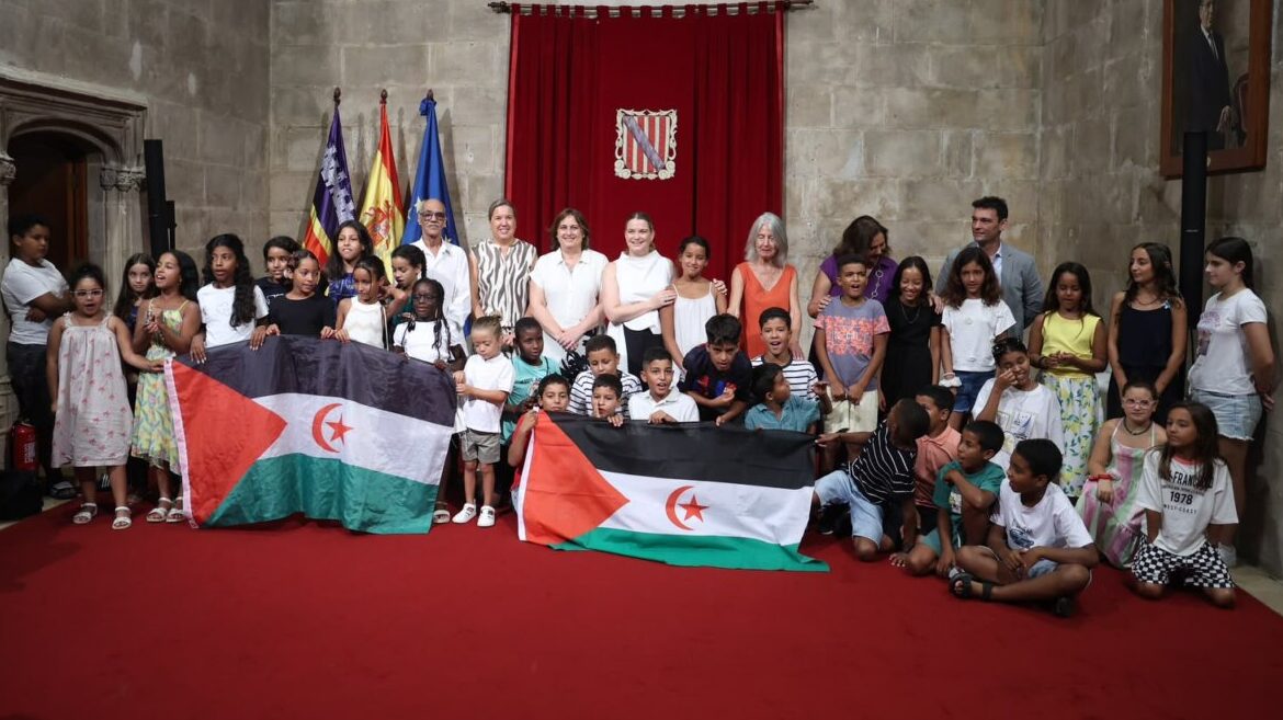 Grupo de ni&ntilde;os sosteniendo banderas en un evento