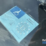 Tarjeta de aparcamiento para personas con movilidad reducida en un vehículo.