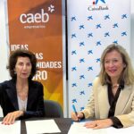 Dos mujeres firmando un convenio entre CAEB y CaixaBank