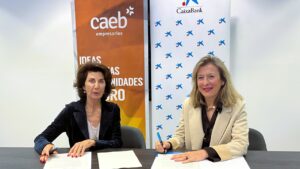 Dos mujeres firmando un convenio entre CAEB y CaixaBank