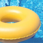 Flotador amarillo en una piscina azul, s&iacute;mbolo de seguridad acu&aacute;tica.