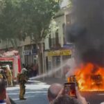 Un coche en llamas siendo apagado por bomberos en Palma.
