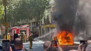 Un coche en llamas siendo apagado por bomberos en Palma.