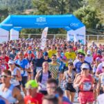 Corredores participando en la Half Marathon Magaluf bajo un arco de meta