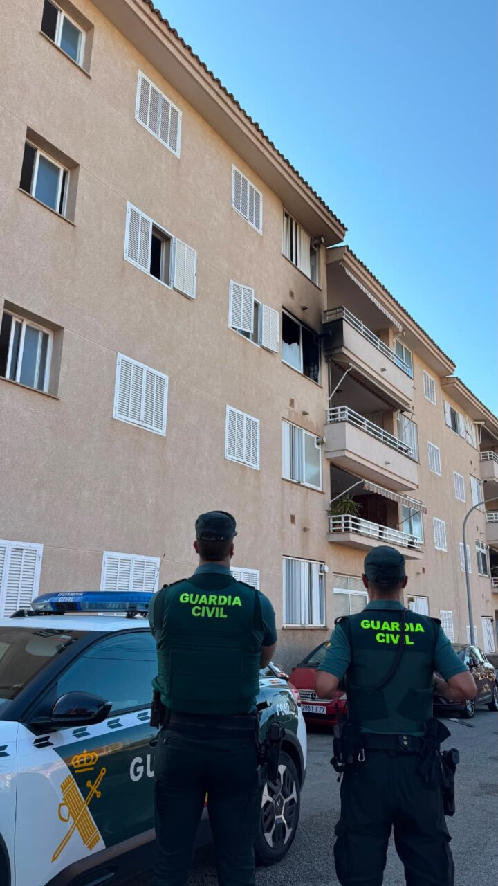 Dos guardias civiles observan un edificio da&ntilde;ado por un incendio en Cala Rajada