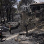 Bomberos trabajando en un incendio forestal cerca de una casa en Madrid