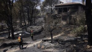 Bomberos trabajando en un incendio forestal cerca de una casa en Madrid