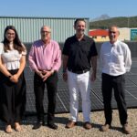 Cuatro personas junto a paneles solares en una instalaci&oacute;n energ&eacute;tica