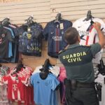 Agente de la Guardia Civil inspeccionando camisetas en tienda de Mallorca