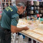 Agente de la Guardia Civil revisando joyas falsificadas en una tienda