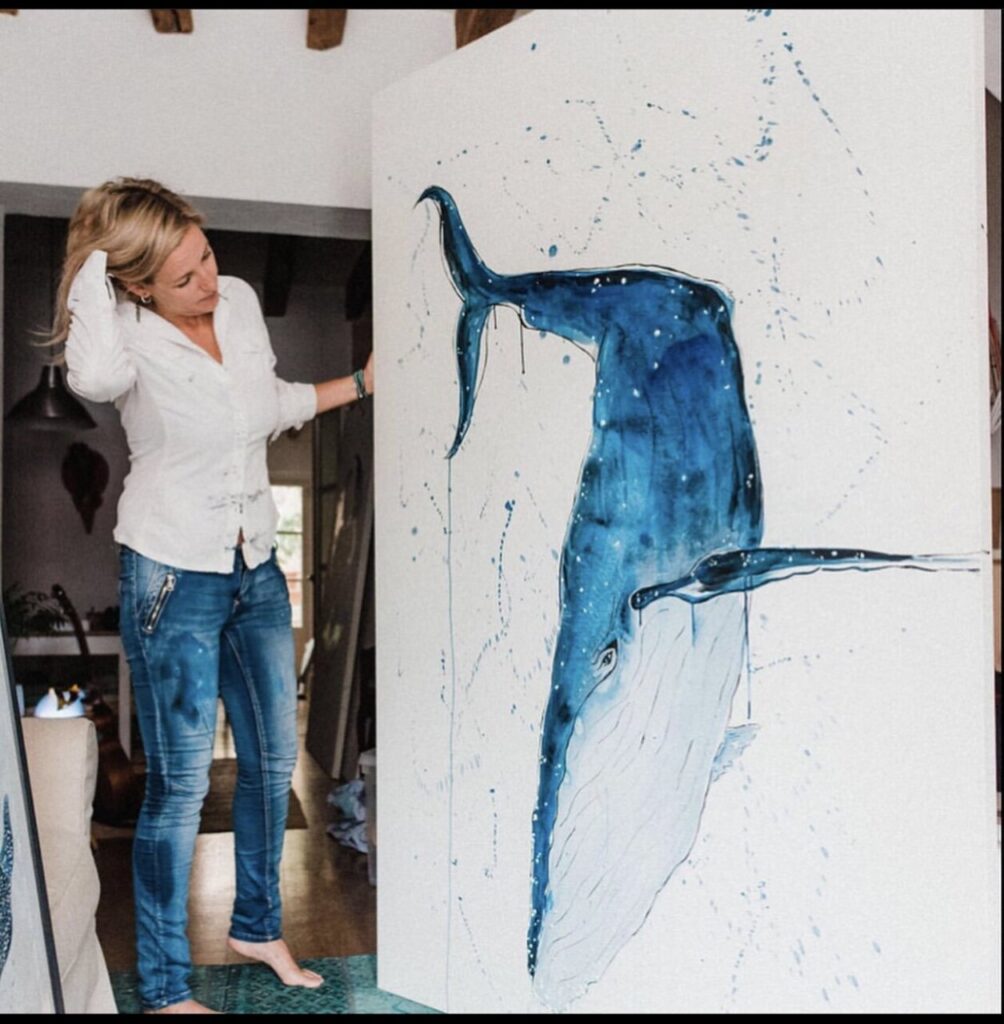Jennifer Nicholson pintando una acuarela de una ballena en su estudio.