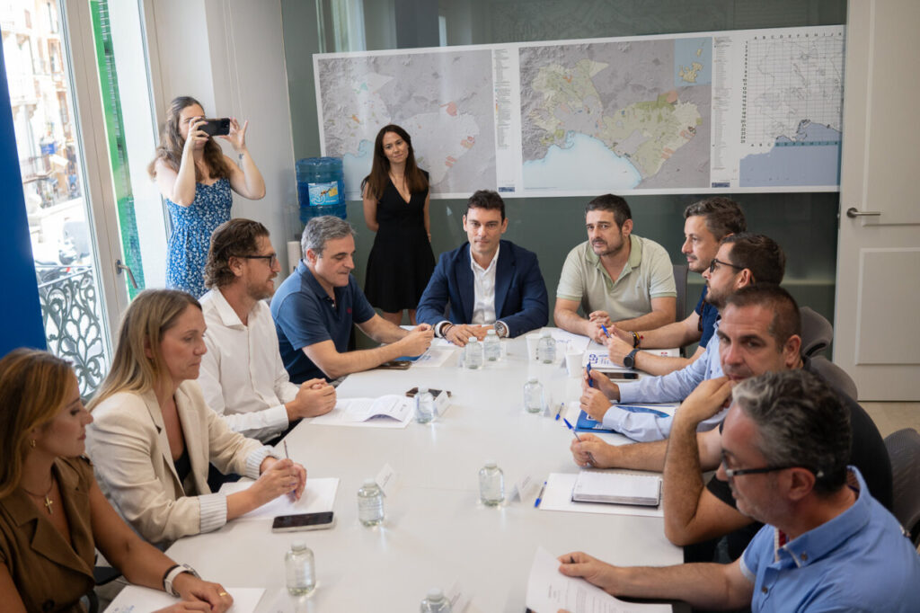 Reuni&oacute;n de trabajo sobre la propuesta de ley migratoria en una mesa con varios participantes.