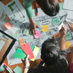 Grupo de personas trabajando en diseño de interiores con planos y materiales